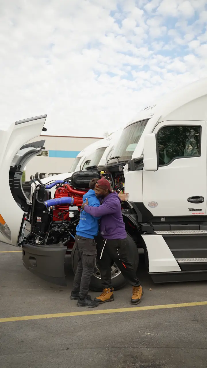 Two Pro Star team members greeting each other at a truck